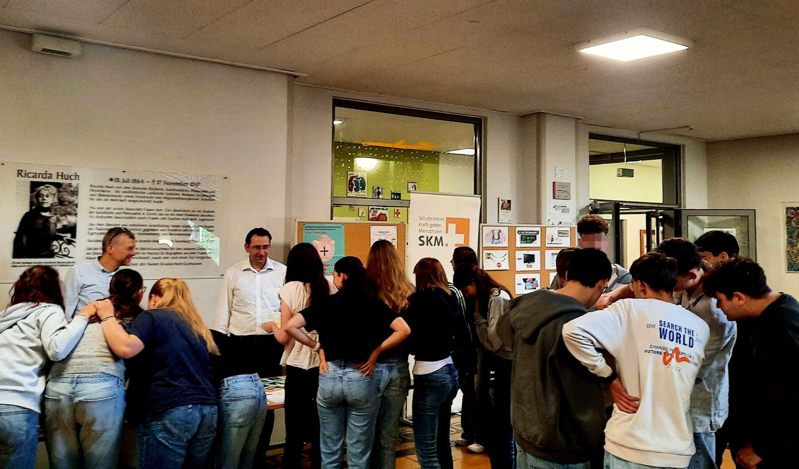 Schülerinnen und Schüler eines Gymnasiums informieren sich zum Thema Finanzbildung an einem Stand